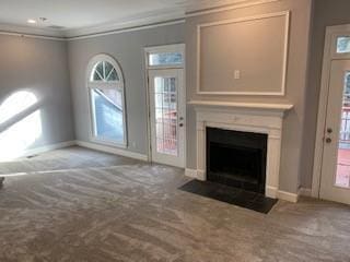 unfurnished living room with carpet floors, a fireplace, baseboards, and crown molding