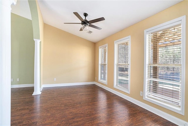 empty room with ceiling fan, dark hardwood / wood-style flooring, ornate columns, and lofted ceiling