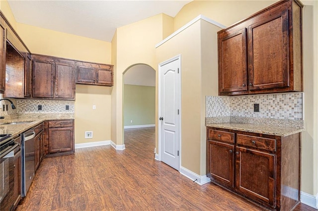 kitchen featuring decorative backsplash, dark hardwood / wood-style flooring, stainless steel appliances, and light stone counters