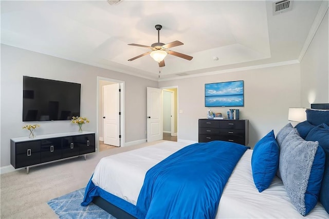 bedroom with ceiling fan, light colored carpet, ornamental molding, and a tray ceiling