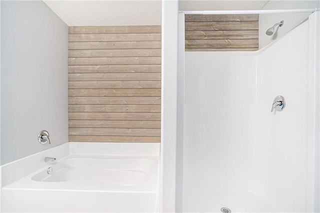 bathroom with a washtub and a textured ceiling