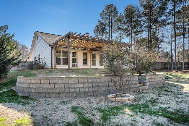 back of property with a pergola and a lawn