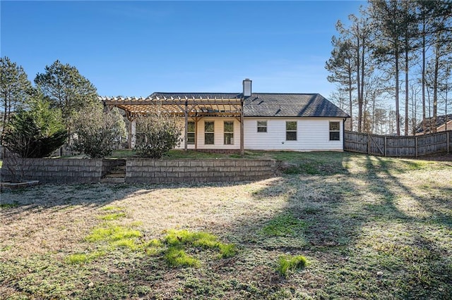 rear view of house with a pergola and a lawn