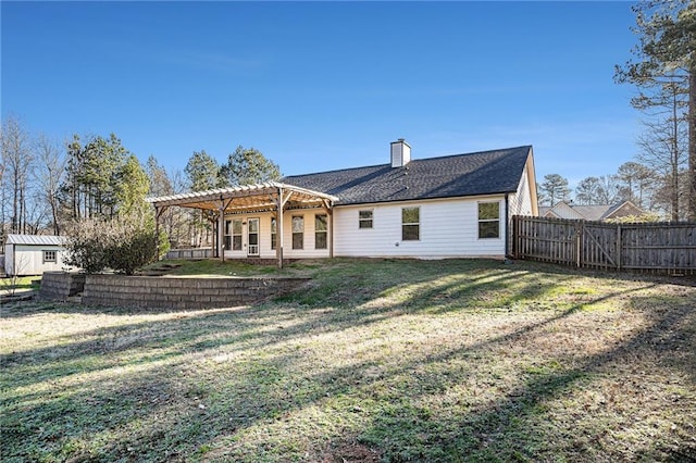 rear view of house with a pergola and a lawn