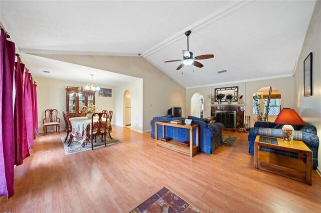 living room featuring lofted ceiling with beams, crown molding, wood-type flooring, and ceiling fan with notable chandelier