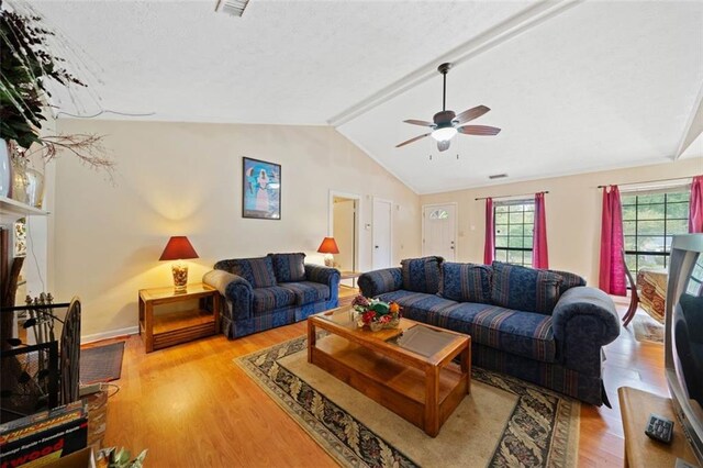 living room with vaulted ceiling with beams, ceiling fan, and light hardwood / wood-style flooring