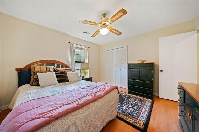 bedroom featuring light wood-type flooring, a closet, and ceiling fan