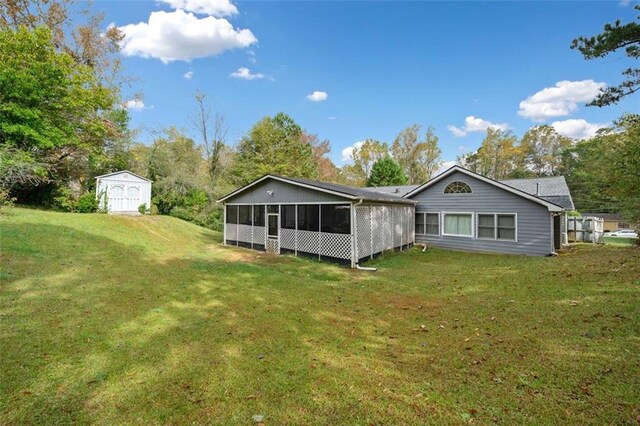 rear view of property featuring a sunroom, a yard, and a storage unit