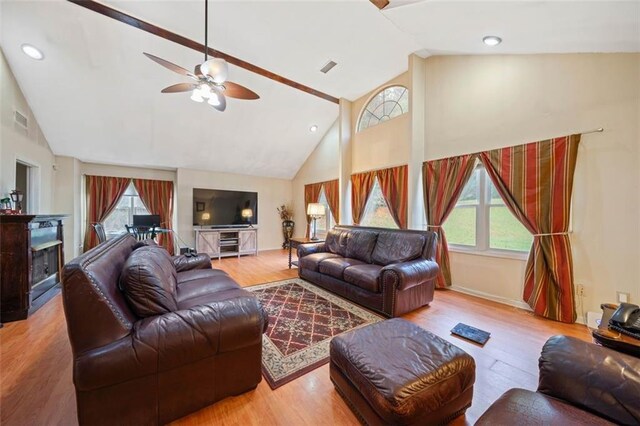 living room with light hardwood / wood-style floors, high vaulted ceiling, a wealth of natural light, and ceiling fan