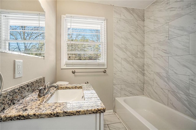 bathroom featuring vanity, tiled shower / bath combo, and a healthy amount of sunlight