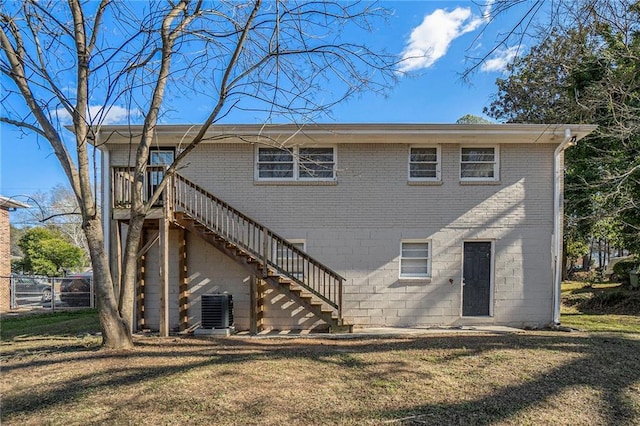 back of property with a lawn and central AC