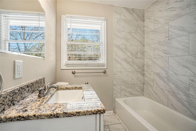 bathroom with vanity, tiled shower / bath combo, and plenty of natural light