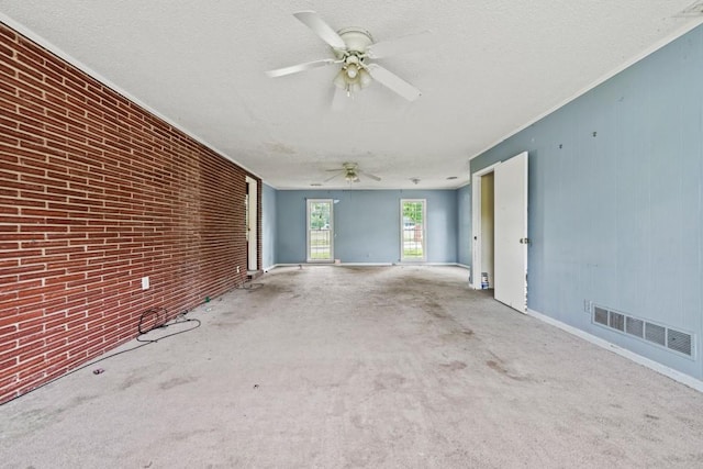 10 Shadburn Ferry Rd, Buford, GA 30518 - unfurnished living room featuring carpet floors, a ceiling fan, brick wall, and a textured ceiling