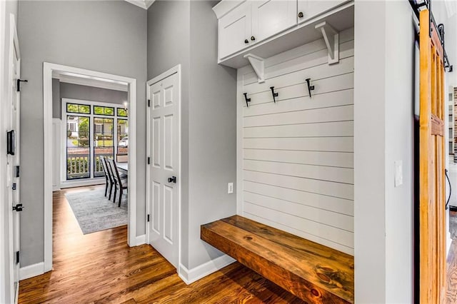 mudroom featuring dark wood finished floors, baseboards, and a barn door