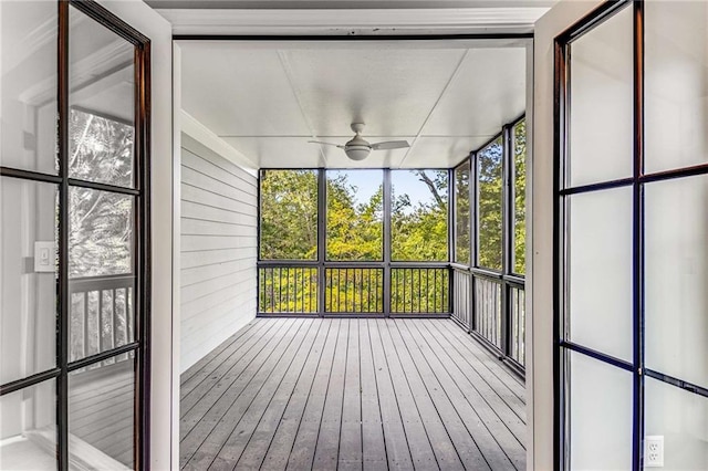 unfurnished sunroom with ceiling fan