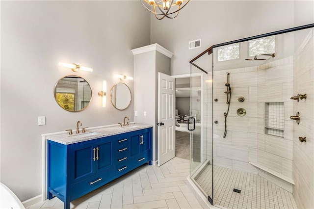 bathroom with double vanity, a sink, visible vents, and a shower stall