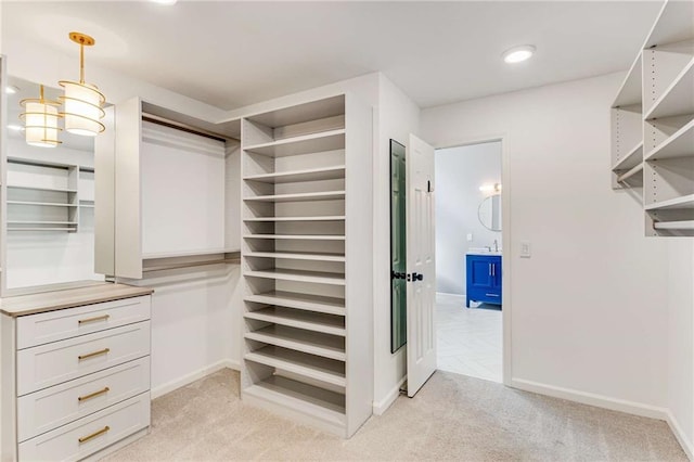 spacious closet with light carpet and a sink