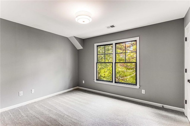 carpeted spare room featuring visible vents and baseboards