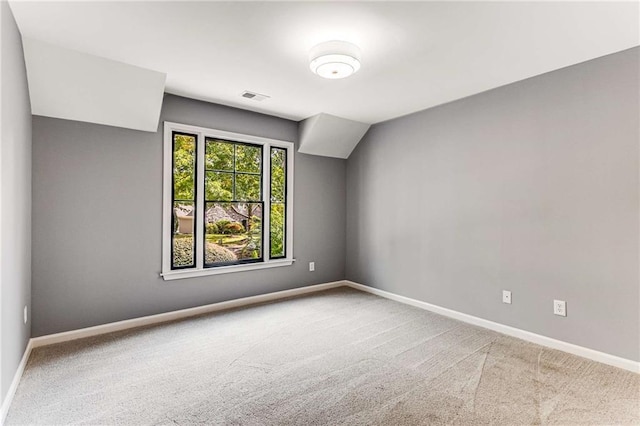 spare room with carpet, visible vents, and baseboards