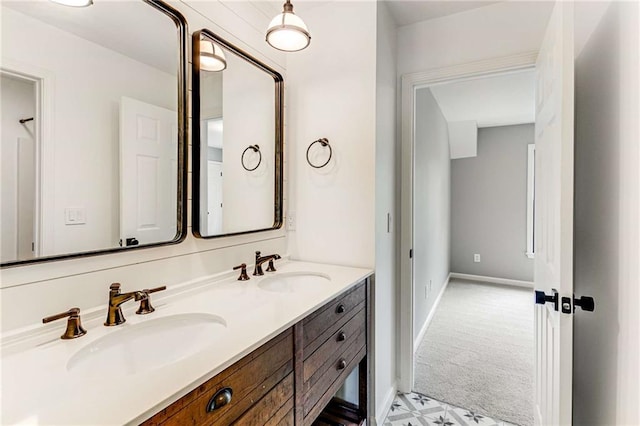 bathroom featuring double vanity, a sink, and baseboards