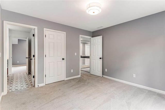 unfurnished bedroom featuring carpet floors and baseboards