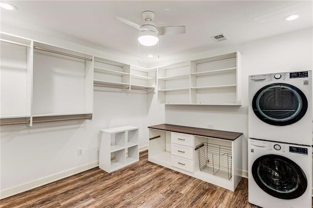 laundry room featuring laundry area, wood finished floors, visible vents, baseboards, and stacked washer and clothes dryer