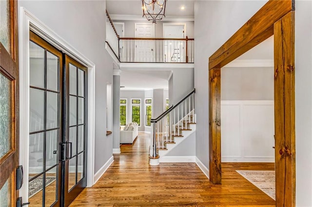 entrance foyer with stairs, wood finished floors, and crown molding