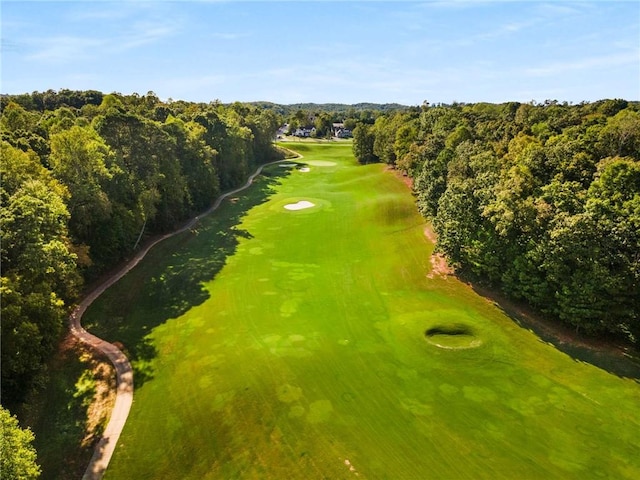 birds eye view of property with view of golf course and a wooded view