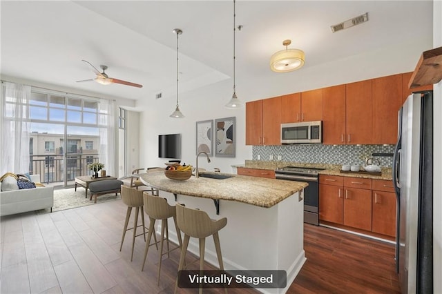 711 Cosmopolitan Dr NE Unit 802, Atlanta, GA 30324 - kitchen with appliances with stainless steel finishes, open floor plan, dark wood finished floors, a ceiling fan, and brown cabinets