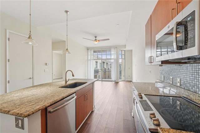 711 Cosmopolitan Dr NE Unit 802, Atlanta, GA 30324 - kitchen featuring stainless steel appliances, brown cabinets, ceiling fan, dark wood-type flooring, and decorative backsplash