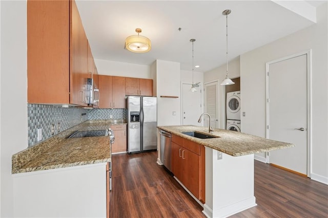 711 Cosmopolitan Dr NE Unit 802, Atlanta, GA 30324 - kitchen featuring stainless steel appliances, stacked washer and clothes dryer, dark wood finished floors, and brown cabinetry