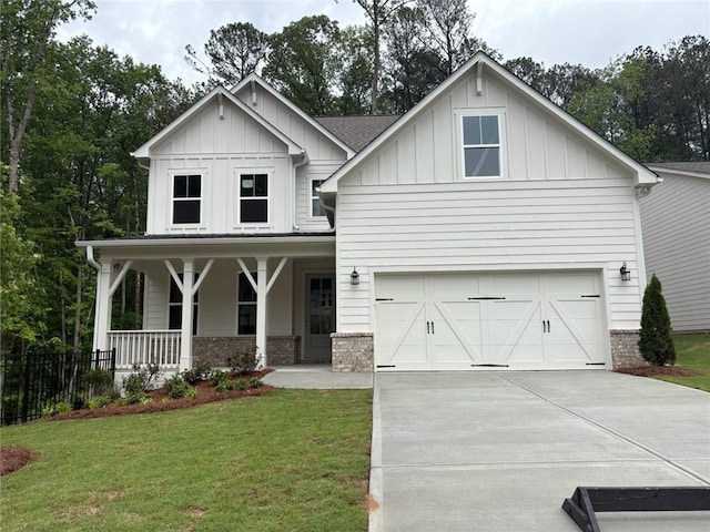 view of front of home with a front lawn, brick siding, board and batten siding, a porch, and driveway