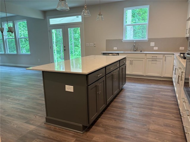 kitchen with a kitchen island, white cabinetry, a sink, and tasteful backsplash