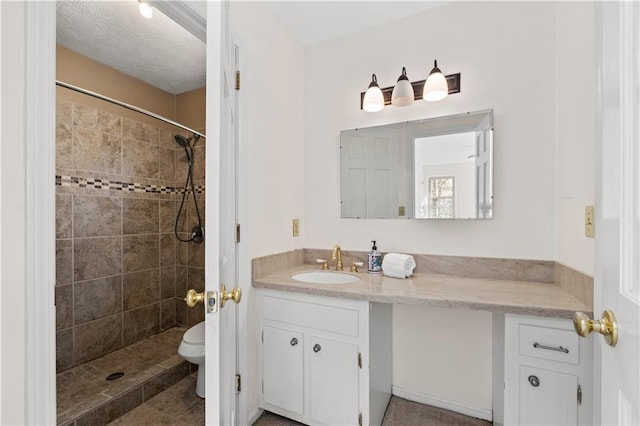 bathroom featuring vanity, toilet, and tiled shower