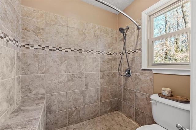 bathroom featuring toilet and tiled shower