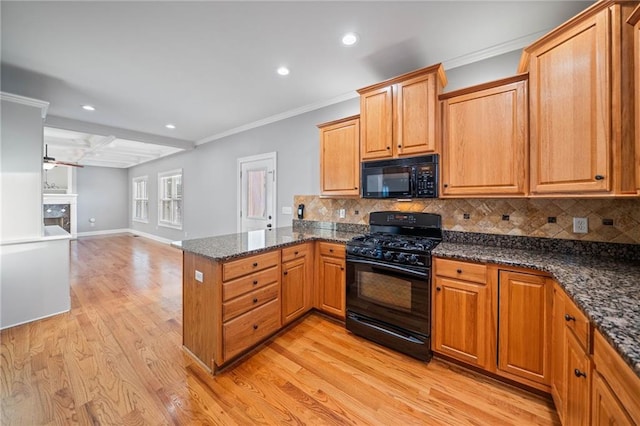 kitchen featuring light hardwood / wood-style flooring, dark stone countertops, backsplash, black appliances, and kitchen peninsula