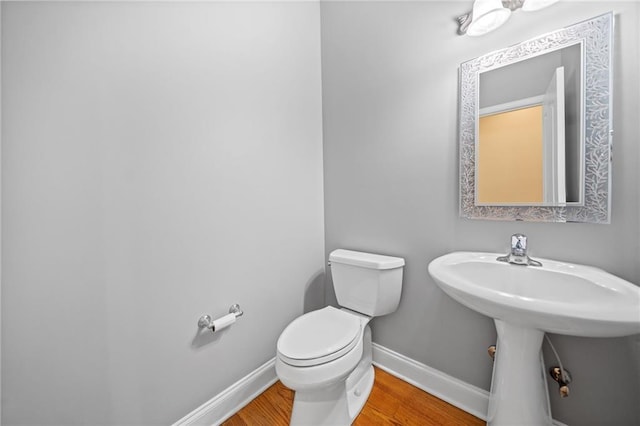 bathroom with sink, hardwood / wood-style flooring, and toilet