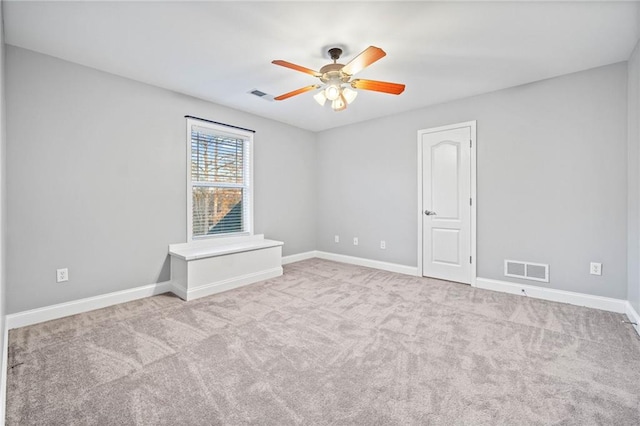 carpeted spare room with ceiling fan