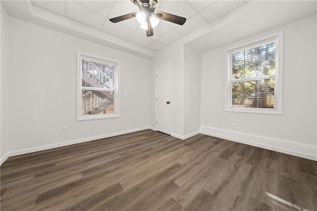 unfurnished room featuring a paneled ceiling, ceiling fan, and dark wood-type flooring