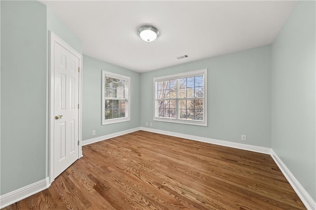 unfurnished room with hardwood / wood-style floors