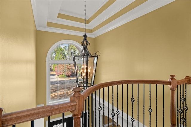 stairs featuring a tray ceiling, a chandelier, and ornamental molding