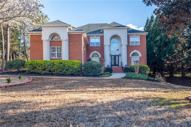 neoclassical home featuring french doors and a front lawn