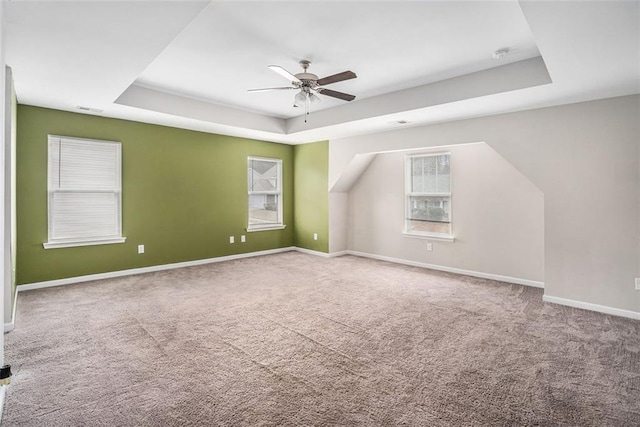additional living space with baseboards, visible vents, ceiling fan, and carpet flooring