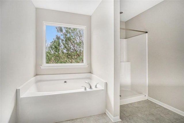 bathroom featuring tile patterned floors, baseboards, a garden tub, and a walk in shower