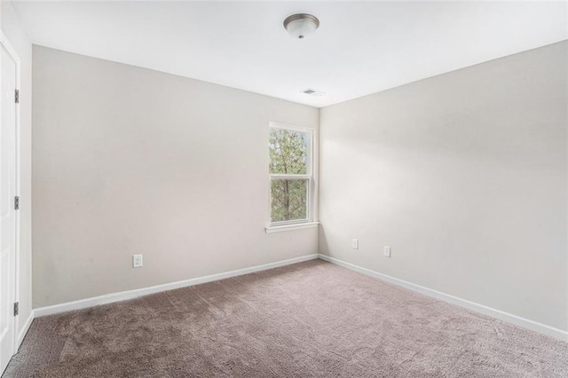 empty room featuring baseboards and carpet floors