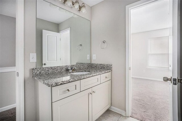 bathroom featuring tile patterned flooring, vanity, and baseboards