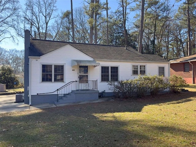 ranch-style home featuring cooling unit and a front yard