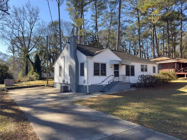 view of front of house featuring cooling unit and a front yard