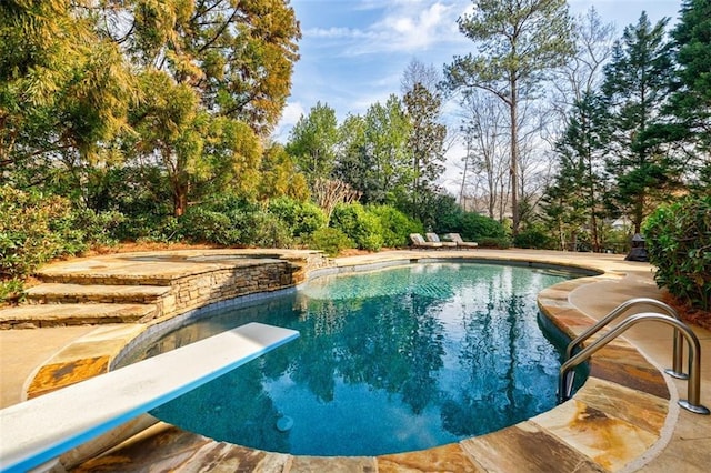 view of pool with a diving board and a patio area