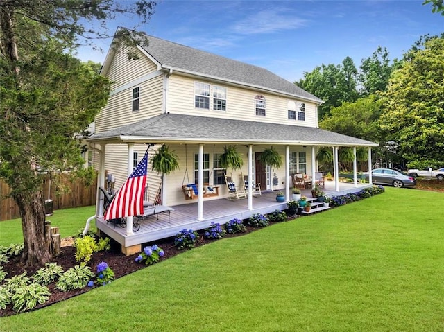 back of property with a yard and covered porch